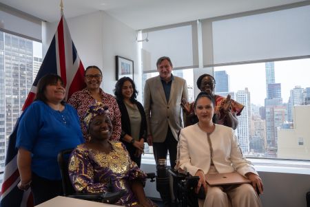 Rosario Galarza Meza from IDA, joins Kemi Williams from FCDO, Kaushiki Ghose from BBC Media Action, Johannes Trimmel and Gertrude Oforiwa Fefoame from Sightsavers, Lois Auta from the Network of Women with Disabilities, and Cara Yar Khan from the Global Disability Innovation Hub for a photo at the UK Mission in New York. They are all smiling at the camera.